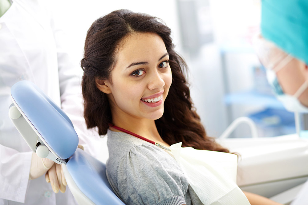 Smiling woman seated at orthodontic appointment