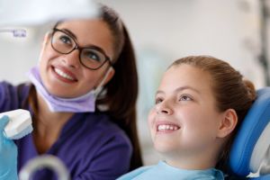Smiling child seated at orthdontics appointment