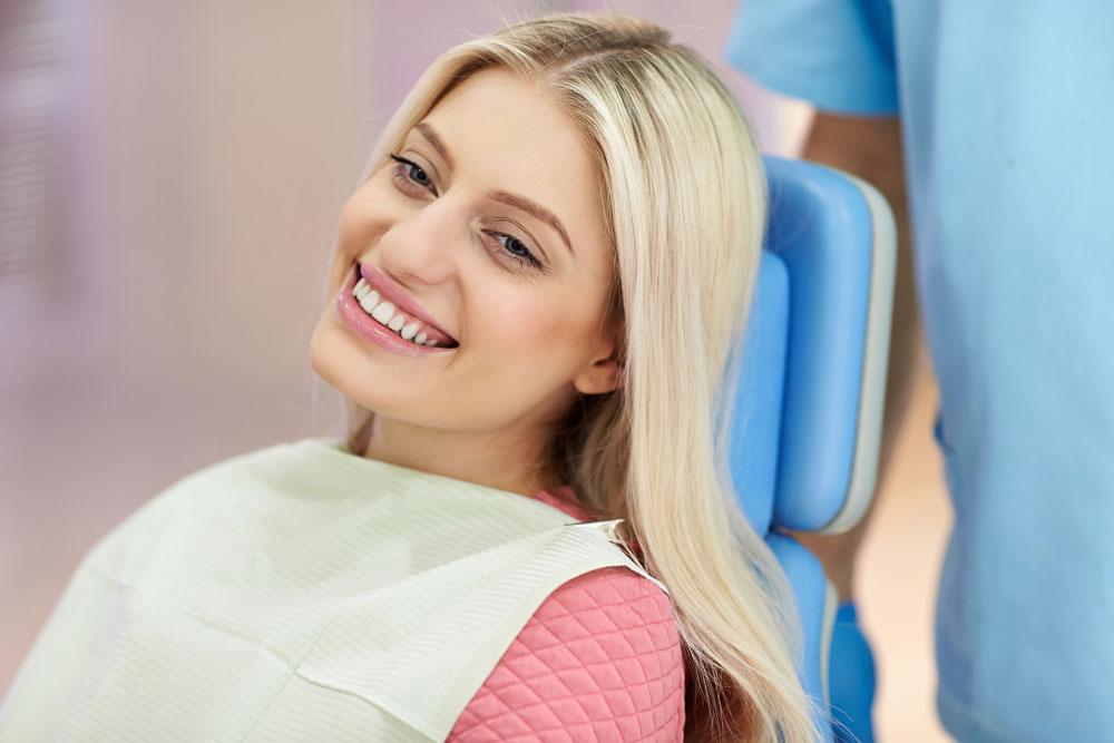 Smiling young woman at orthodontics appointment | Life after braces