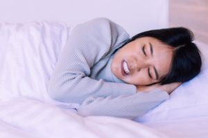 Sleeping young woman with bruxism symptoms