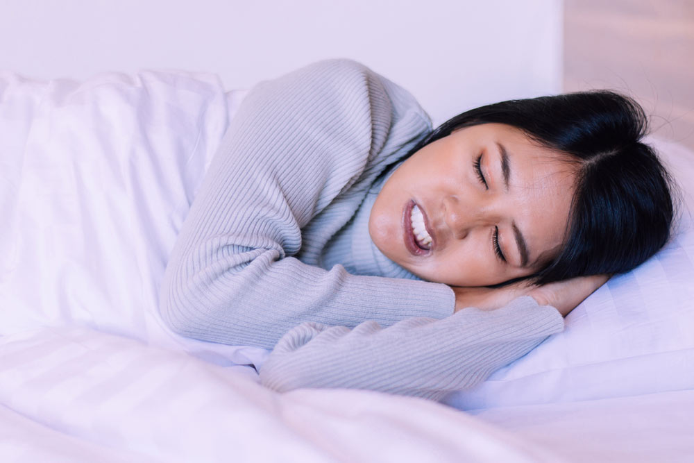 Sleeping young woman with bruxism symptoms